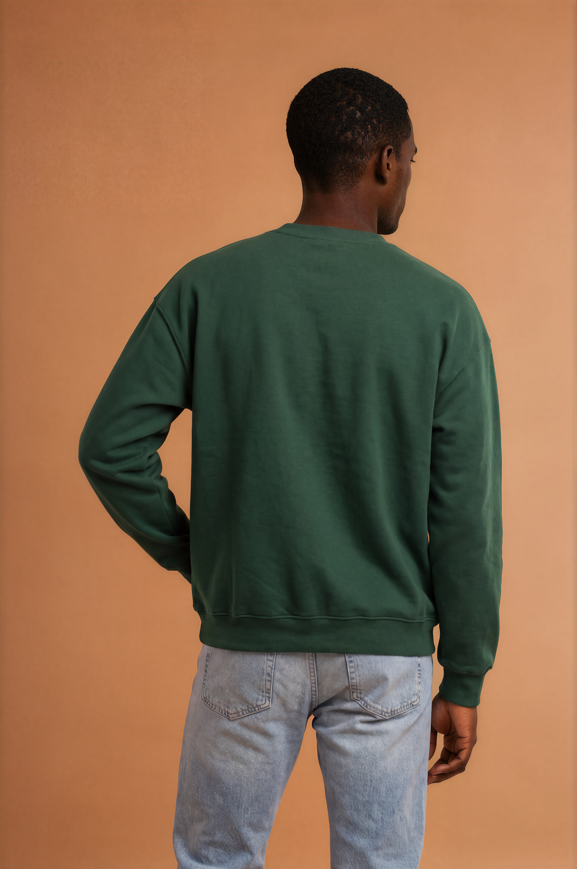 Man wearing a forest green Powerful Mind Club crewneck sweatshirt, back view