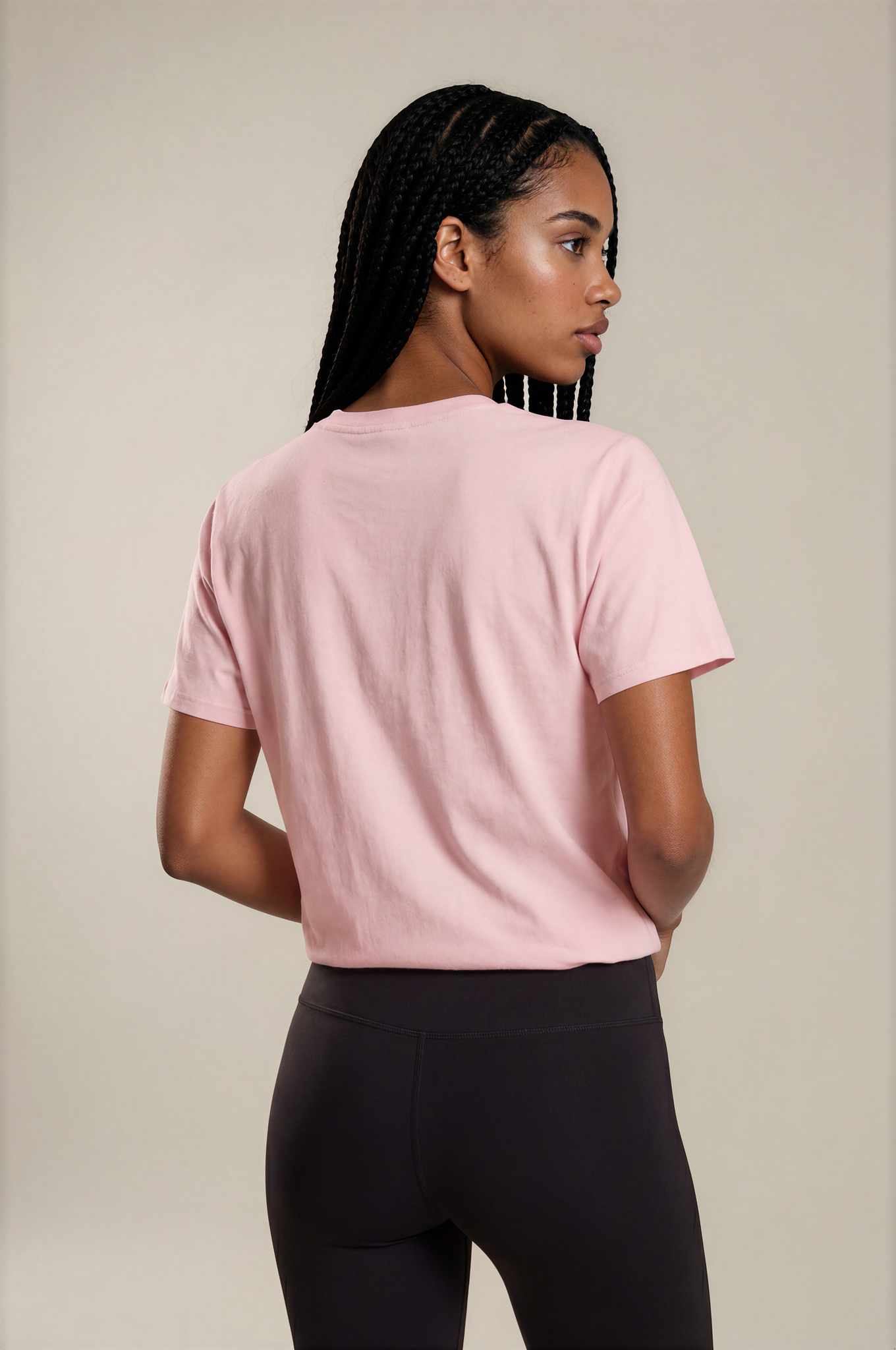 Woman wearing a pink Powerful Mind Club unisex organic t-shirt, back view